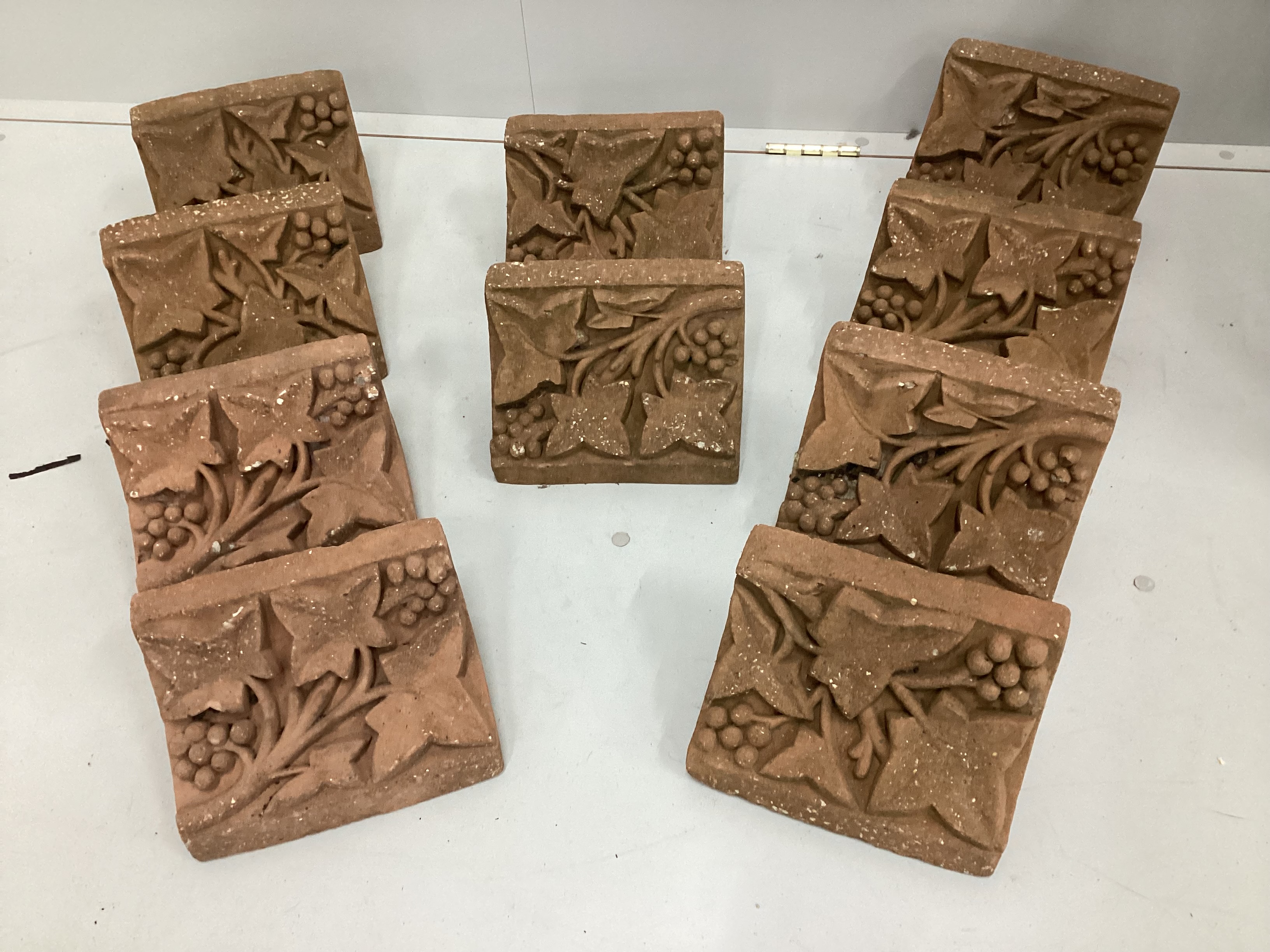 A set of ten cast terracotta fruiting vine corbels, each 23cm wide, depth 15cm, height 13cm